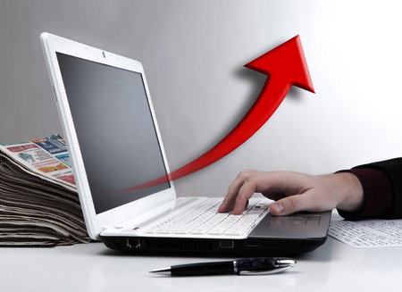 human hand on the notebook keyboard and red arrowの写真素材