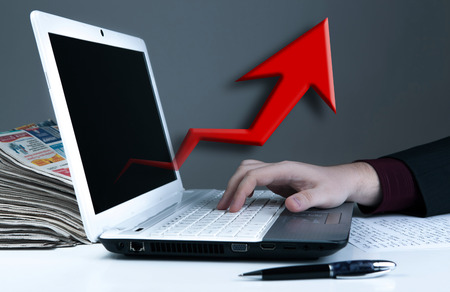 human hand on the notebook keyboard and red arrowの写真素材