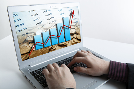 human hands over laptop keyboard and graphicsの写真素材