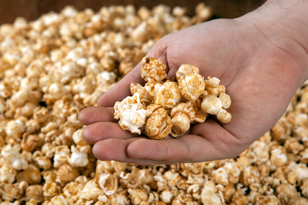 man holds a handful of popcorn in his hands close upの写真素材