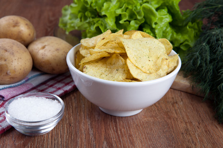 glass bowl with potato chips and vegetablesの写真素材