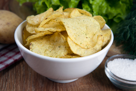 glass bowl with potato chips and vegetablesの写真素材