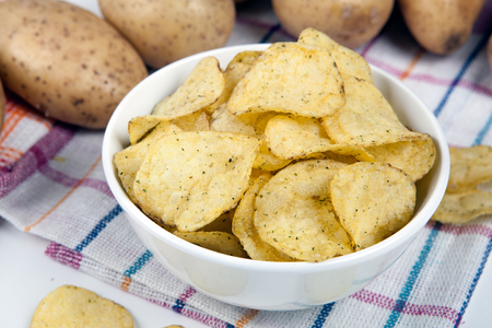 still life from a glass bowl with potato chips close upの写真素材