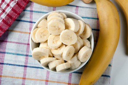 Slices of fresh bananas in a bowl close upの写真素材