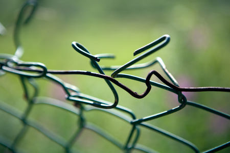 broken mesh fence as a symbol of defencelessness close upの写真素材