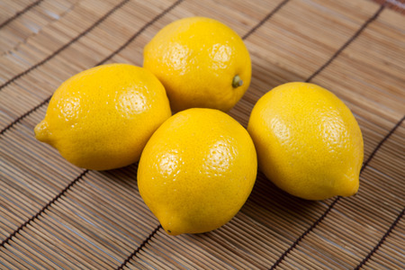 Still life of fresh lemons on a bamboo napkin close upの写真素材