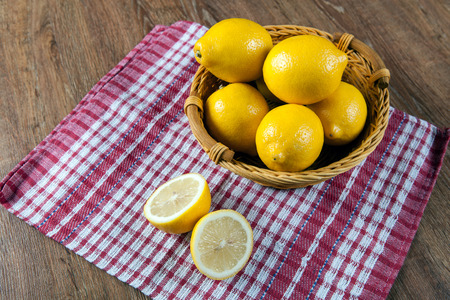 Still life of fresh lemons in a basket and a napkin close upの写真素材