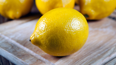 Still life of the one fresh lemon on board close upの写真素材