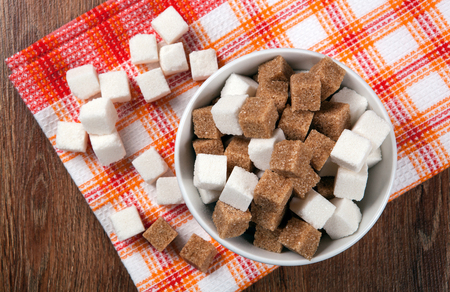 white bowl with cubes of white and brown sugar with a napkinの写真素材