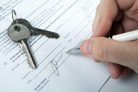apartment keys, apartment plan, mortgage loan document and a human handの写真素材