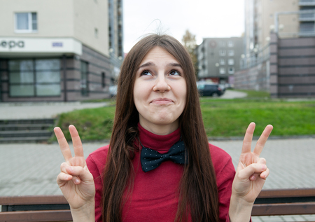 expressive portrait of a young cheerful girl on a city landscapeの写真素材