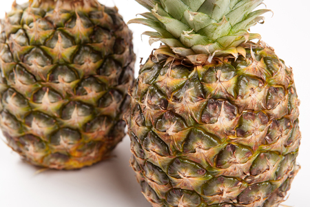 two big pineapples on a white background closeupの写真素材