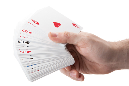 fan of playing cards in hand on a white background isolatedの写真素材