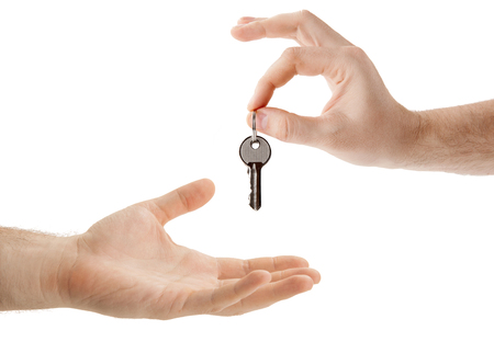 hands over the keys to the apartment from hand to hand closeup isolatedの写真素材
