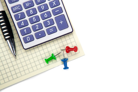One big calculator and stationery on a white table closeupの写真素材