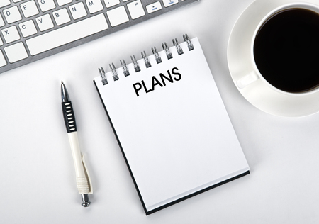 notebook with an inscription plans and keyboard on the desktop closeupの写真素材