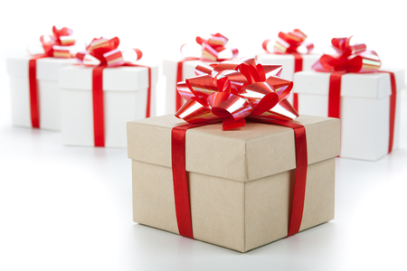 One festive gift box with a red bow against a background of white boxesの写真素材