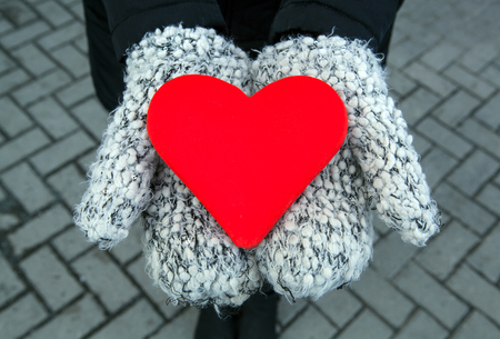 red heart sign in hands with mittens closeupの写真素材