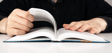 man is looking for information in the dictionary closeup