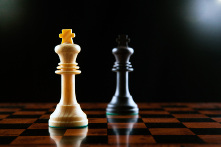 chess duel of two kings on a black background close upの写真素材