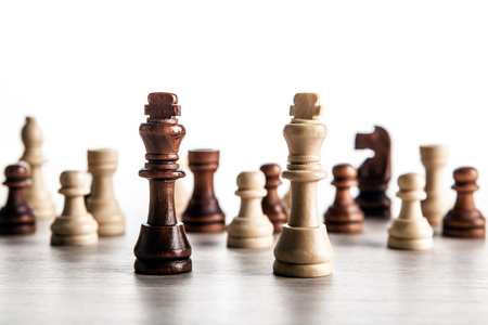 chess pieces on a grey background and black and white chess kings close upの写真素材