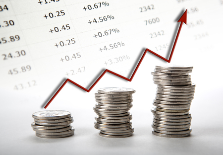 three stacks of coins with red diagram progress close upの写真素材