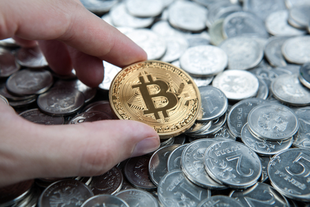 gold coin bitcoin in the hand on russian ruble coins  close upの写真素材