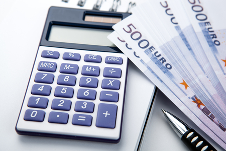 business still-life from a calculator and a bundle of banknotes 500 euros close upの写真素材