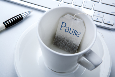 business still life of a cup with a tea bag on the desktop close upの写真素材