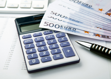 business still-life from a calculator and a bundle of banknotes 500 euros close upの写真素材