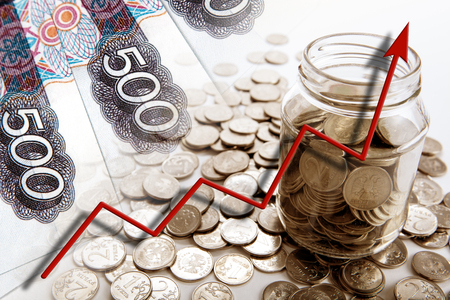 business still life of money bills and coins with a bank and a graph of progress close upの写真素材