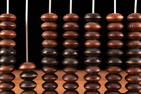antique abacus with knuckles on a table on a black background close up