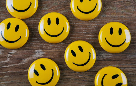 emoticon icons on wooden background top viewの写真素材