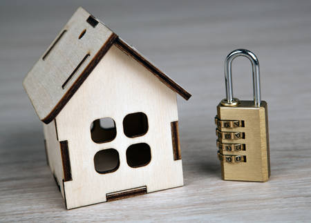 wooden miniature house with with brass padlock close upの写真素材