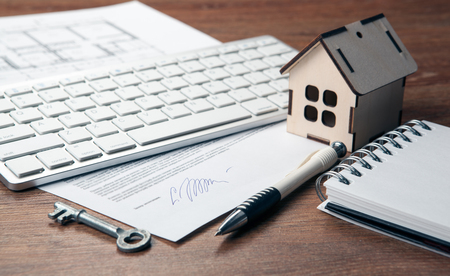 home purchase contract, miniature house, door key, keyboard close upの写真素材