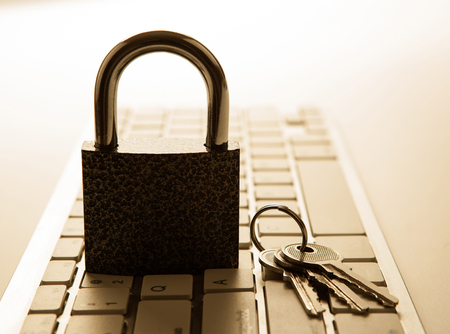 Door lock with keys on a computer keyboard close upの写真素材