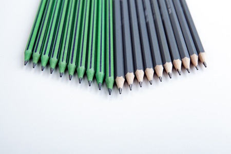 many simple pencils with erasers in a row on a white table close upの写真素材