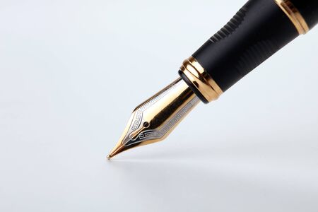 golden fountain pen writes on a white background closeupの写真素材