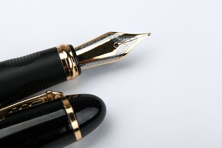 golden fountain pen on a white paper closeupの写真素材