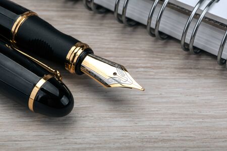 fountain pen near the notepad on a wooden table  closeupの写真素材