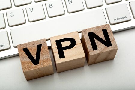 three wooden cubes with inscription VPN with the computer keyboard close upの写真素材