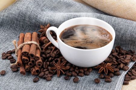 cup of black coffee on colored cloth and roasted coffee beansの写真素材