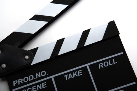 black movie clapper with white inscriptions on a white table closeupの写真素材