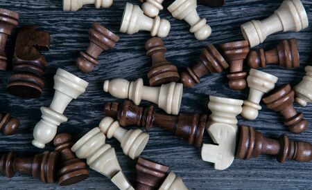 scattered chess pieces on a wooden background close upの写真素材