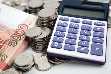 a bundle of russian banknotes and many Russian coins and calculator stil life closeupの写真素材