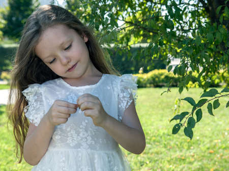 beautiful little girl in a white dress as a portrait closeupの写真素材