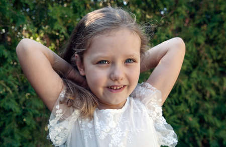 little girl in a pink dress on a green lawn portraitの写真素材