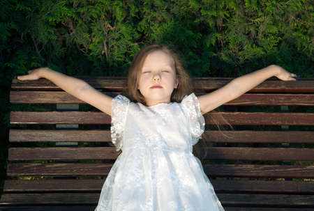little girl in a pink dress on a green lawn portraitの写真素材
