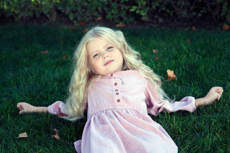 beautiful little girl in a white dress as a portrait closeupの写真素材