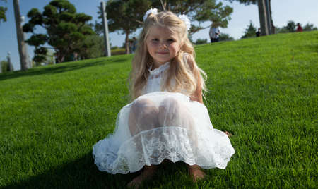beautiful little girl in a white dress as a portrait closeupの写真素材